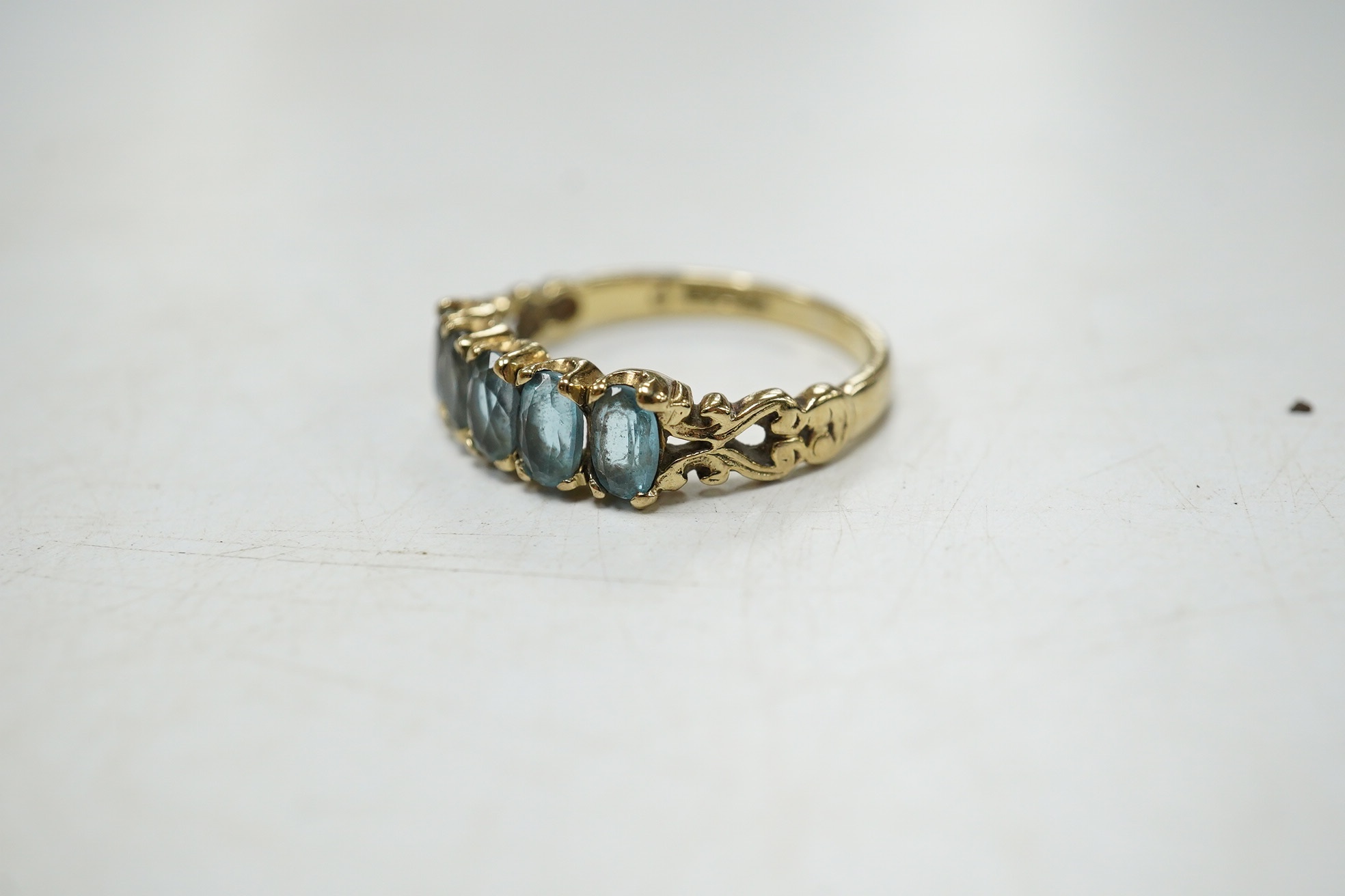 A modern 9ct gold and five stone oval cut blue topaz set half hoop ring, size N/O, gross weight 2.7 grams. Condition - poor to fair